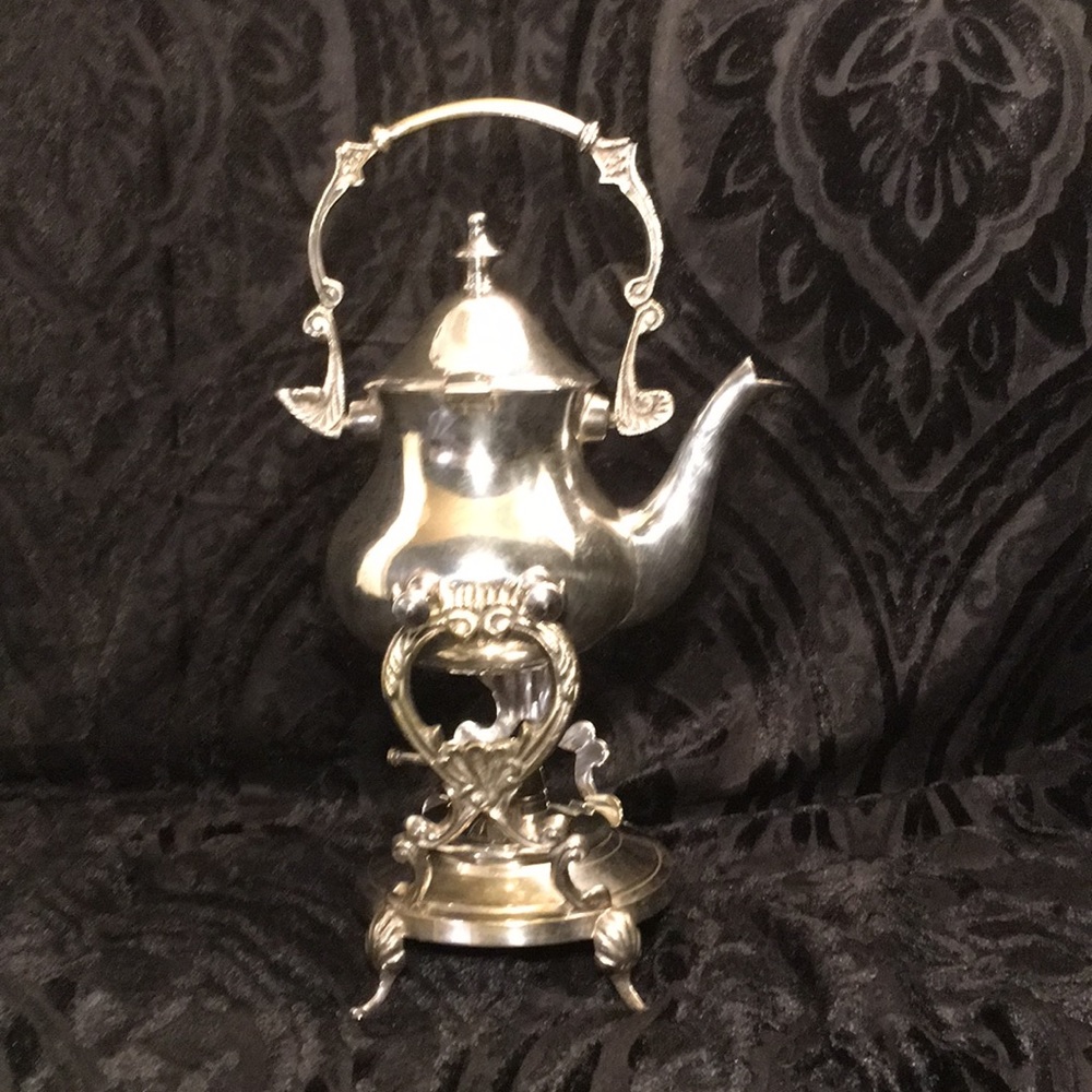 Tilting silver plated tea kettle with warmer.